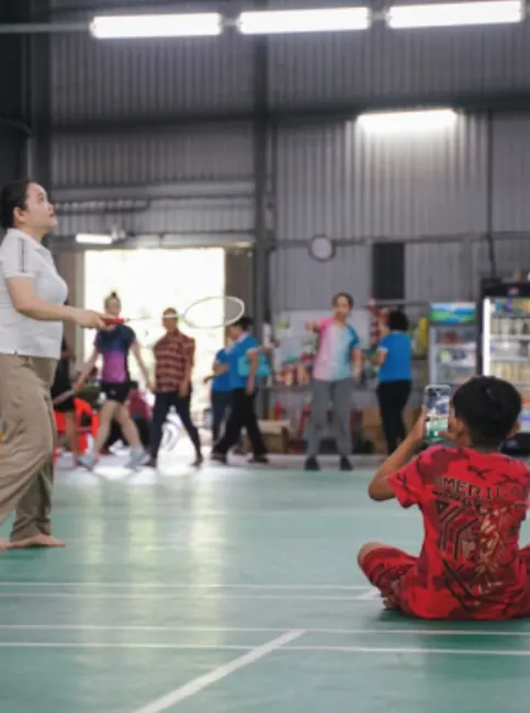 A junior badminton squad session in a sports hall.